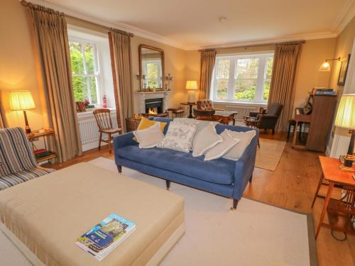 a living room with a blue couch and a table at Knockanboy House in Ballymoney