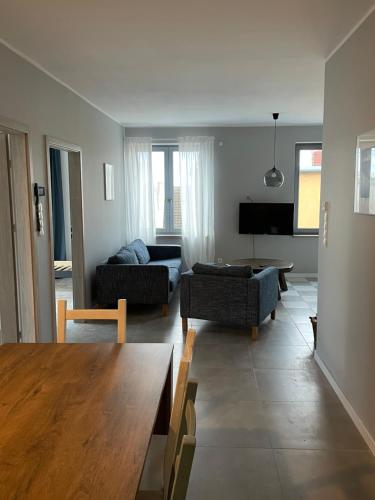 a living room with a couch and a table at Apartamenty Komorniki in Komorniki