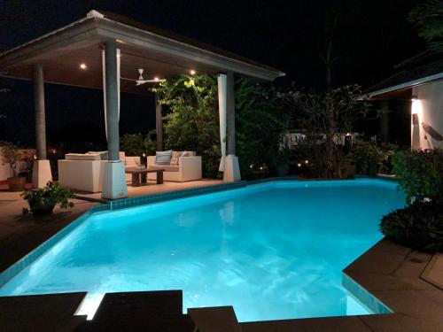 a swimming pool at night with a gazebo at Samui Blu, villa with private pool in Choeng Mon Beach