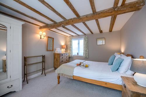 a bedroom with a large bed and a wooden ceiling at The Hayloft Boundary Farm Air Manage Suffolk in Woodbridge