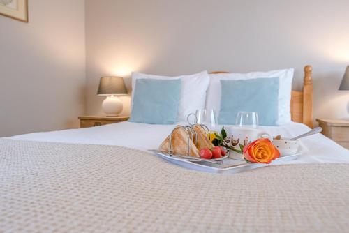 a tray with bread and fruit on a bed at The Hayloft Boundary Farm, Framlingham in Woodbridge