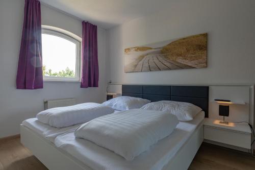 - une chambre avec un lit doté de draps blancs et une fenêtre dans l'établissement Residence Juliana appartement 53 -Julianadorp aan zee, à Julianadorp