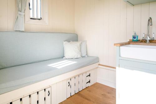a bench in a kitchen with a sink at Sage Shepherds Hut Boundary Farm Air Manage Suffolk in Woodbridge