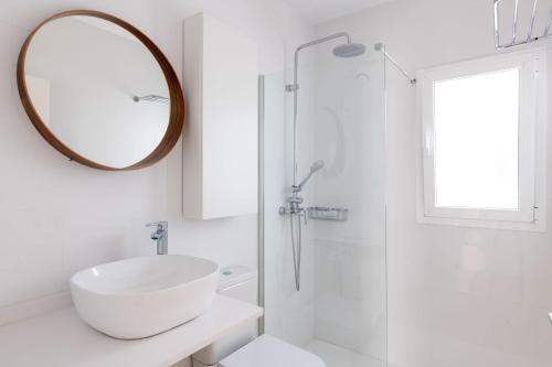 een witte badkamer met een wastafel en een spiegel bij NAZARET URBAN in Arrecife