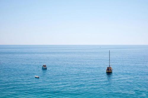 two boats in a large body of water at Albatros Beach Hotel in Letojanni
