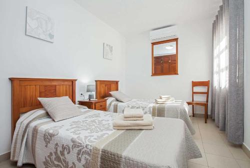 プラヤ・ブランカにあるAlexsandraのベッドルーム1室(ベッド2台、椅子付)
