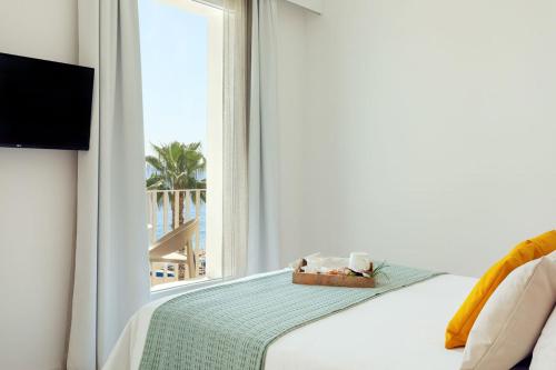 a bedroom with a bed and a window with a view of the beach at Albatros Beach Hotel in Letojanni