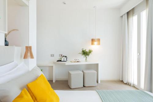a white bedroom with a bed and a table at Albatros Beach Hotel in Letojanni