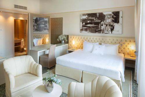 a bedroom with a large white bed and a chair at Palazzo Barocci in Venice