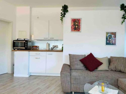 a living room with a couch and a kitchen at Schönes Bungalow, Check-In Kontaktlos, Zentral in Duisburg