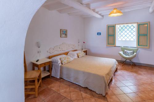 a bedroom with a bed and a table and a chair at Villa Ginestra sulla spiaggia di Stromboli in Stromboli