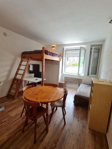 a room with a table and a bunk bed at Le Français, studio au calme proche de la gare in Besançon