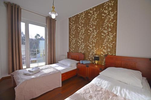 a bedroom with two beds and a window at Apartamenty Bryza - Family Home - Parking - Komandorska 3E-3G in Świnoujście