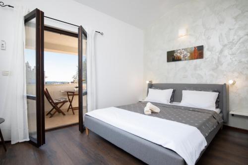 sypialnia z dużym łóżkiem i balkonem w obiekcie Sandy Bay Apartments - free mountainbike rental - w mieście Pješčana Uvala
