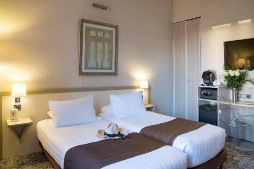 una habitación de hotel con una cama grande con sábanas blancas en Best Western Alba, en Niza