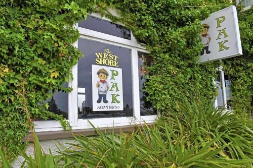 a window of a west store with signs in it at Comfort Inn Westshore Beach in Napier