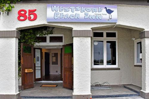 un edificio con un cartel que lee el club de playa Wetstridge en Comfort Inn Westshore Beach, en Napier