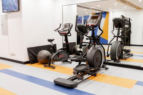 a gym with treadmills and exercise bikes at Resivation Hotel in Dubai
