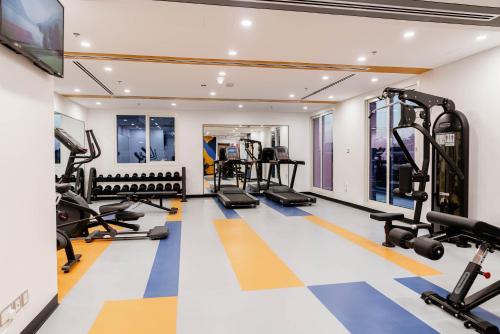 a gym with treadmills and ellipticals at Resivation Hotel in Dubai