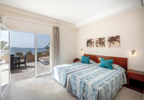 Apartamentos Vista Sur في بلايا ذي لاس أميريكاس: غرفة نوم مع سرير وإطلالة على المحيط