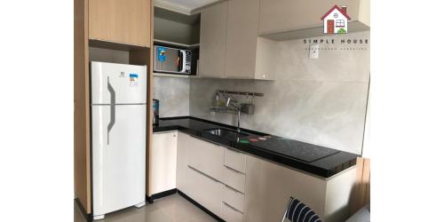 uma pequena cozinha com geladeira e pia em Aluga-se por temporada em Vitória