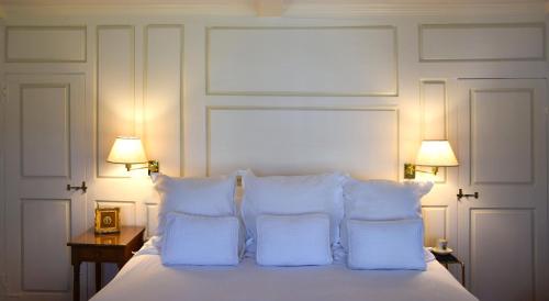 a white bed with pillows and two lamps on a table at 29 India House in Nantucket