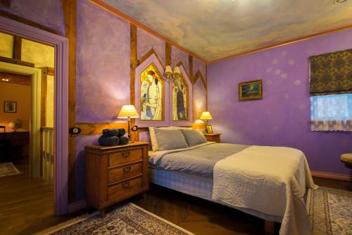 a bedroom with a bed and a purple wall at Old Town Fairytale, 2 bedrooms and terrace, Tartu Home in Tartu