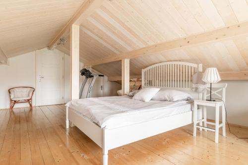 uma cama branca num quarto com tecto em madeira em Babiogórska Perełka w skandynawskim stylu z sauną i kominkiem em Jordanów