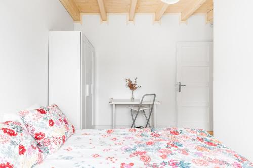 a white bedroom with a bed and a table at Babiogórska Perełka w skandynawskim stylu z sauną i kominkiem in Jordanów