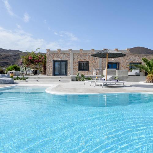 una grande piscina con ombrellone di fronte a una casa di Villa Beltramo Santorini 2 bedroom private pool villa a Foinikiá