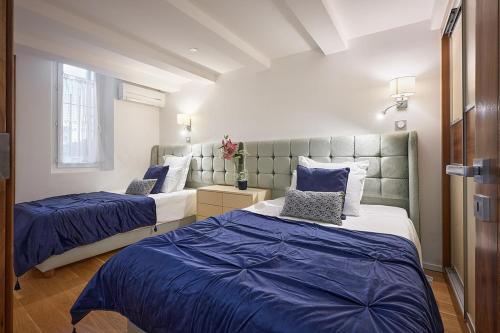 deux lits dans une chambre avec du bleu et du blanc dans l'établissement Sunlight Properties - Palme D Or - 2 Bedrooms, modern holiday rental apartment, hyper central, à Cannes