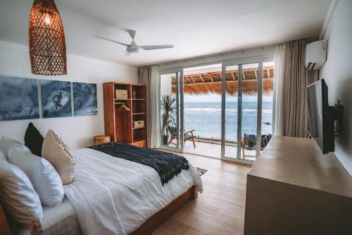 a bedroom with a bed and a view of the ocean at Legends Beachfront Resort in Uluwatu