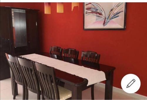 a dining room table with chairs and a painting on the wall at Hall's Home in Gaborone