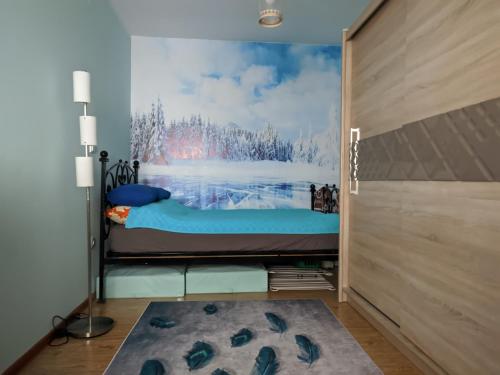 a bedroom with a bed and a painting on the wall at Apartman Mina in Kopaonik