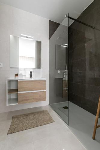 a bathroom with a shower and a sink and a mirror at Salty Soul in Ferrel