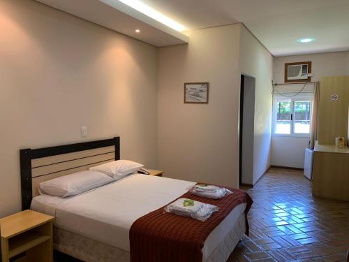 um quarto de hotel com uma cama e uma janela em Hotel Tropeiro da Lapa em Lapa
