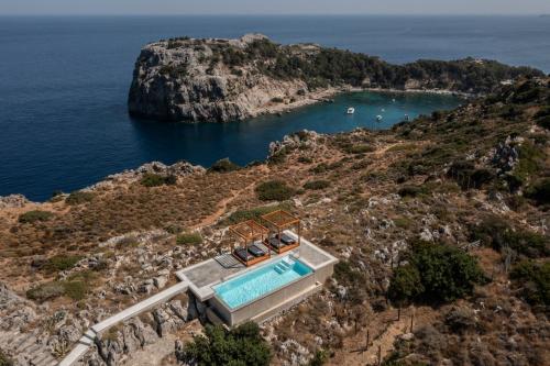 eine Insel mit einem Pool auf einer Klippe in der Unterkunft Pristine Seaview Villa , with 5-Star Resort Access in Faliraki