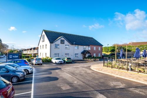 a parking lot with cars parked in front of a building at Two Rivers Lodge by Marston’s Inns in Chepstow