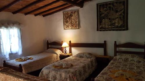 a bedroom with two beds and a lamp and a window at Cabañas La Polaca 2 in Santa Clara del Mar