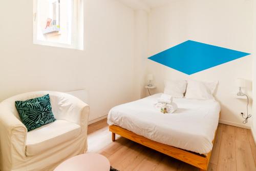 a small bedroom with a bed and a chair at DIFY Les Pentes - Centre-ville in Lyon