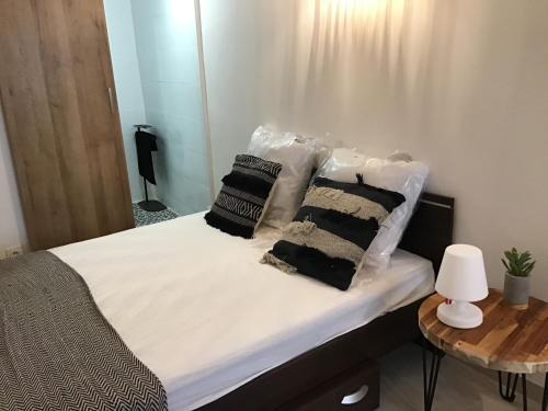 - un lit avec des oreillers en noir et blanc dans l'établissement Loft avec beaucoup de cachet centre historique Montpellier, à Montpellier