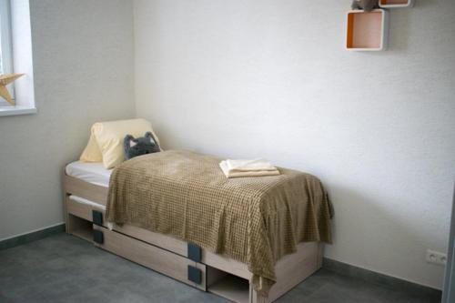 a small room with a bed with a blanket on it at Apartmány Karolin in Uhorská Ves