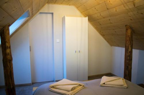 a bedroom with a bed with two towels on it at Apartmány Karolin in Uhorská Ves