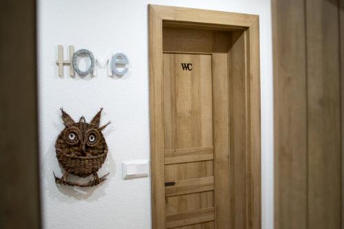 a room with a door with a owl on the wall at Apartmány Karolin in Uhorská Ves