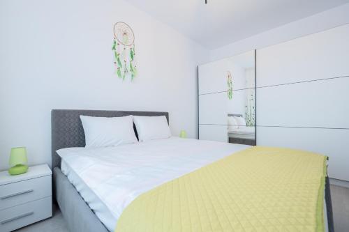 1 dormitorio con 1 cama grande con manta amarilla en Verdi, en Oradea