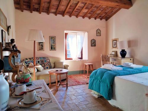 Pokój z łóżkiem, stołem i kanapą w obiekcie Nocini di Maremma w mieście Tatti