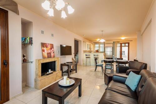 a living room with a couch and a fireplace at Mikra Anogia Villas in Rethymno Town