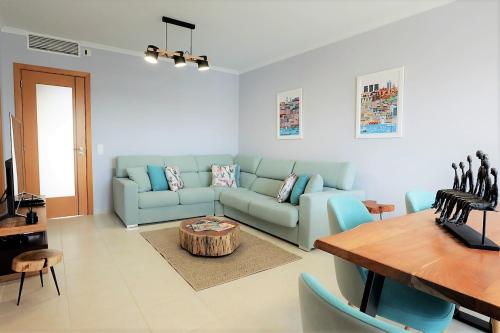 ein Wohnzimmer mit einem blauen Sofa und einem Tisch in der Unterkunft House J São Rafael - By Bedzy in Albufeira