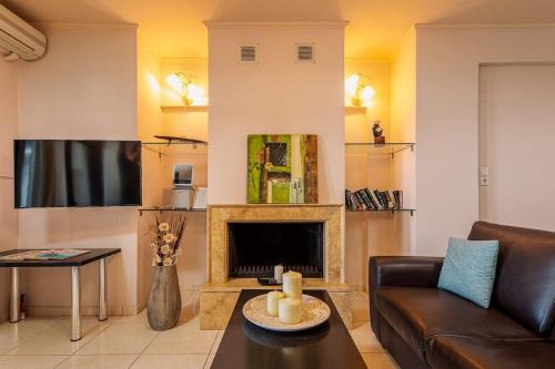 a living room with a couch and a fireplace at Mikra Anogia Villas in Rethymno Town