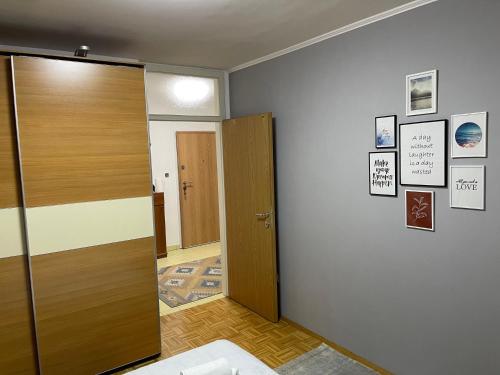 a room with a wooden door and a hallway at Apartment Host in Tuzla